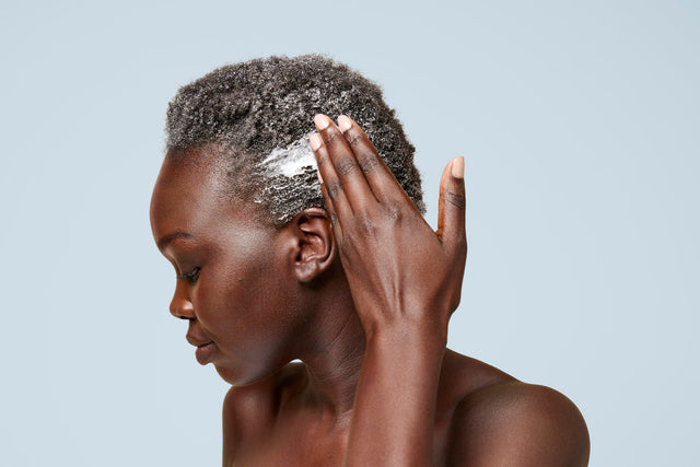 A person with short, coily-textured hair applies Odele Moisture Mask
