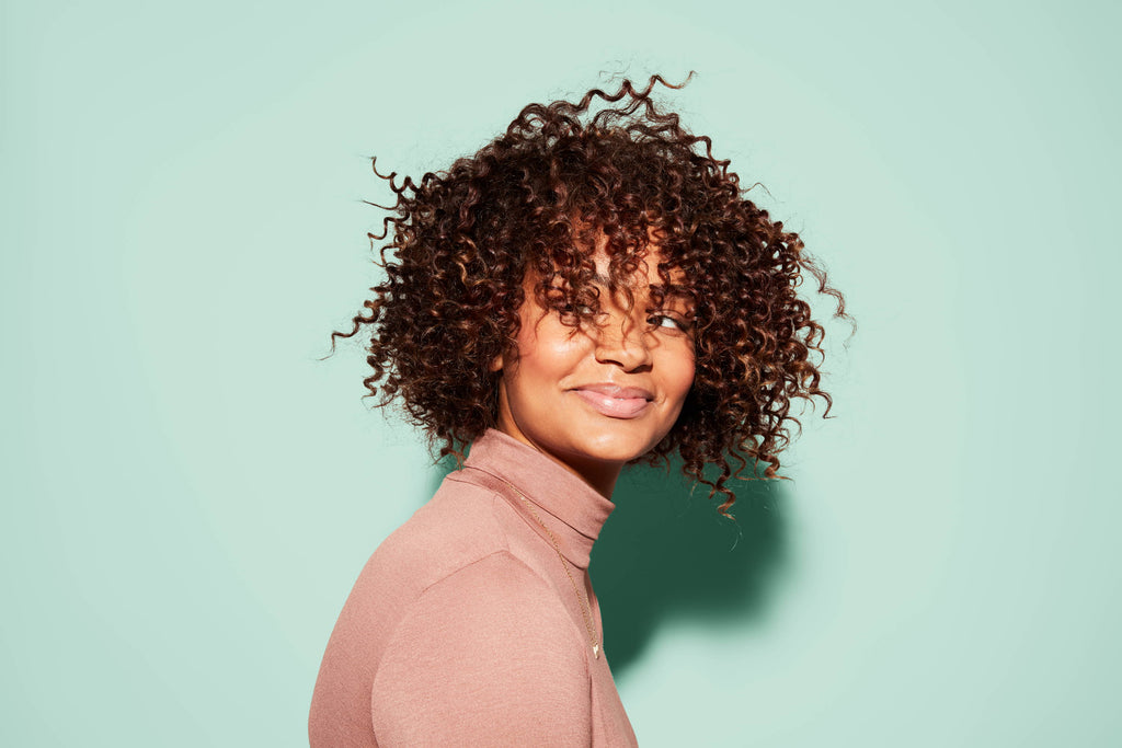 Woman with short coily ringlets of brown hair