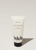 A tube of Odele Air Dry Styler stands upright against a plain, light-colored backdrop with the front of the label facing the camera.