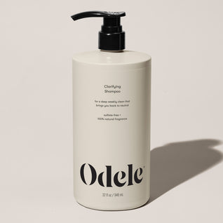 A beige bottle of Clarifying Shampoo Bulk with a black pump, minimalist design, and sulfate-free formula for a gentle clarifying wash. Features 100% natural fragrance.