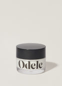 A jar of Odele Cream Pomade stands upright against a plain, light-colored backdrop with the front of the label facing the camera.