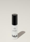 A bottle of Odele Dry Shampoo stands upright against a plain, light-colored backdrop with the front of the label facing the camera.