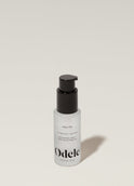 A bottle of Odele Hair Oil stands upright against a plain, light-colored backdrop with the front of the label facing the camera.