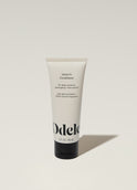 A tube of Odele Leave-in Conditioner stands upright against a plain, light-colored backdrop with the front of the label facing the camera.
