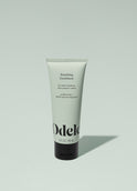 A tube of Odele Smoothing Conditioner stands upright against a plain light green backdrop with the front of the label facing the camera.