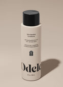 A bottle of Odele Ultra Sensitive Conditioner stands upright against a plain, light-colored backdrop with the front of the label facing the camera.