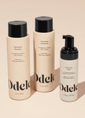 The Odele Volumizing Set stands upright against a plain, light orange backdrop with the front of the labels facing the camera.