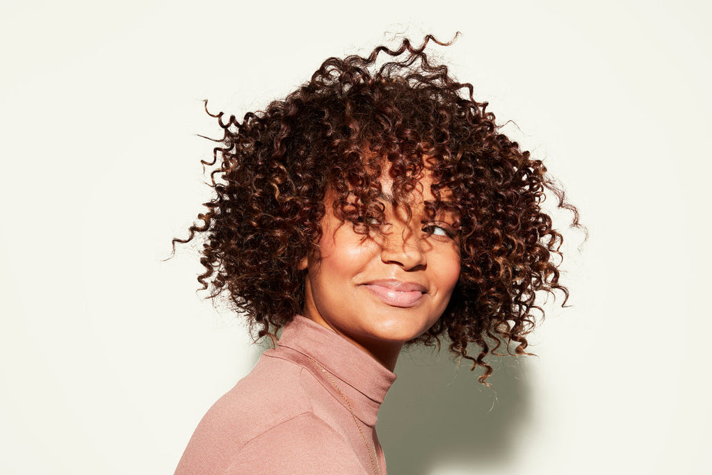 A person with defined, bouncy coily hair