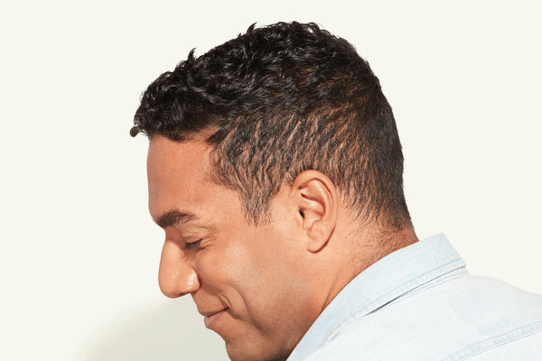 Side profile of a man with short, curly brown hair