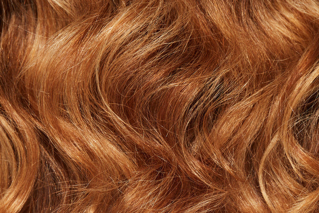 Closeup of shiny, curly red hair. 