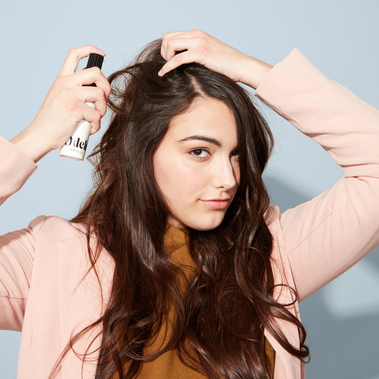 Woman applying dry shampoo to scalp