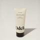 A tube of Odele Air Dry Styler stands upright against a plain, light-colored backdrop with the front of the label facing the camera.