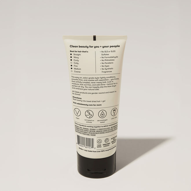 A tube of Odele Air Dry Styler stands upright against a plain, light-colored backdrop with the back of the label facing the camera.