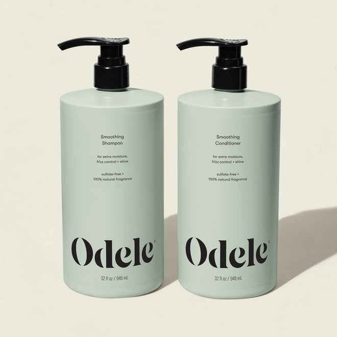 Two mint green pump bottles of Smoothing Duo Bulk (sulfate-free) stand side by side, highlighting frizz control and enhanced shine on a light background.