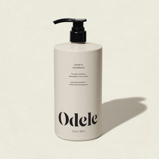 A beige bottle of Leave-in Conditioner Bulk with a black pump and bold black front text stands upright against a light background—ideal for detangling and frizz control.