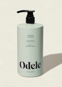 A light green bottle of Smoothing Conditioner Bulk with a black pump, labeled sulfate-free and 100% natural fragrance for frizz control, is shown on a neutral background with a right-side shadow.