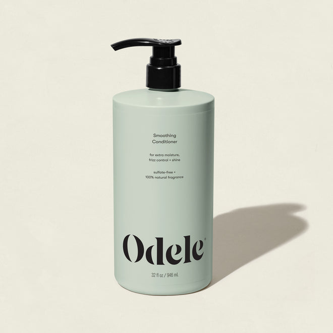 A light green bottle of Smoothing Conditioner Bulk with a black pump, labeled sulfate-free and 100% natural fragrance for frizz control, is shown on a neutral background with a right-side shadow.