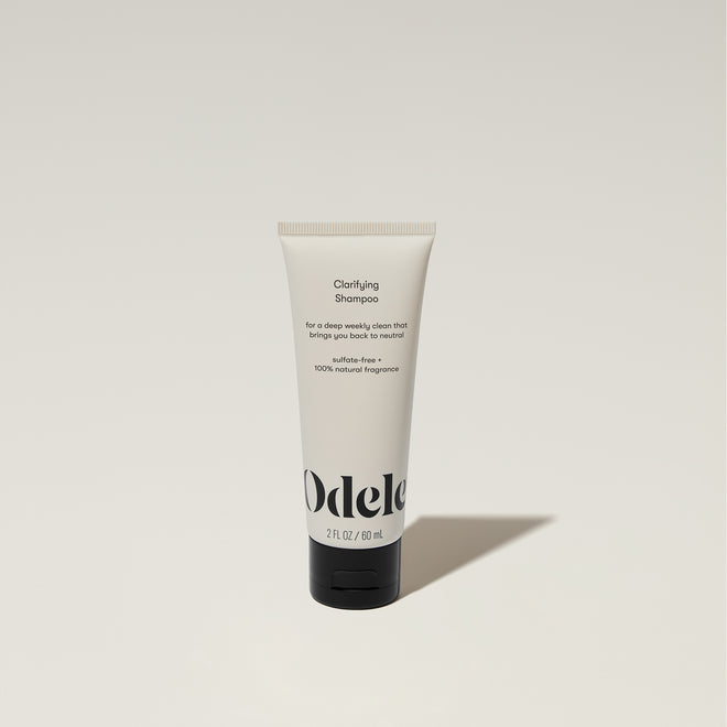 A tube of Odele Clarifying Shampoo stands upright against a plain, light-colored backdrop with the front of the label facing the camera.