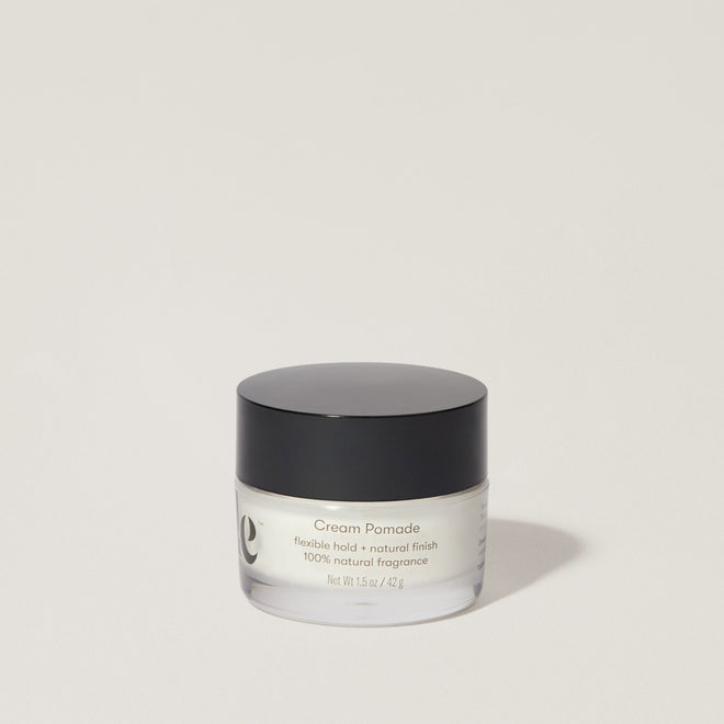 A jar of Odele Cream Pomade stands upright against a plain, light-colored backdrop with the front of the label facing the camera.