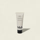 A tube of Leave-in Conditioner Mini, 2 fl oz (60 ml), for detangling and frizz control, stands upright on a light beige background. The off-white tube features black text and a black cap.