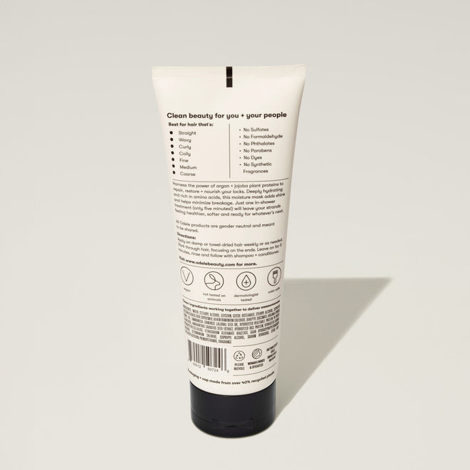 A tube of Odele Moisture Mask stands upright against a plain, light-colored backdrop with the back of the label facing the camera.