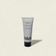 A tube of Moisture Repair Shampoo Mini, 2 fl oz (60 mL), stands upright on a light beige background. The minimalist white tube with black text contains a salon-grade, color-safe shampoo that delivers intense hydration.