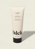A beige tube of Curl Defining Cream stands upright on a light surface, featuring black text that highlights its hydrating, curl-defining, and frizz-control benefits for hair. The tube holds 8 fl oz (236 mL).
