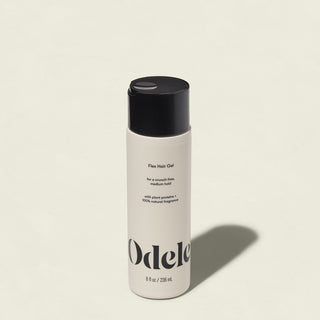 A beige bottle of Flex Hair Gel stands upright on a light background. The label highlights plant protein, natural fragrance, frizz-free definition, medium hold, and an 8 fl oz (236 ml) size.