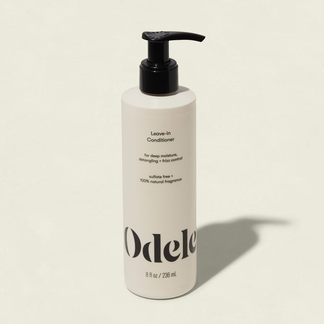 A white bottle of Leave-in Conditioner with a black pump, featuring deep moisture, frizz control, detangling, and sulfate-free care with 100% natural fragrance in an 8 fl oz (236 mL) size.