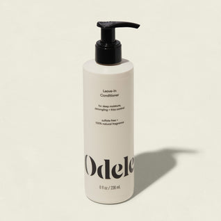 A white bottle of Leave-in Conditioner with a black pump, featuring deep moisture, frizz control, detangling, and sulfate-free care with 100% natural fragrance in an 8 fl oz (236 mL) size.