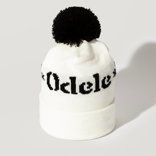 The Good Hair Day Winter Hat is a white knit beanie with a black pom-pom and bold black Odele lettering on the front—a limited-edition, expertly designed accessory for quality comfort.