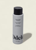 A white bottle of Moisture Repair Conditioner with a black cap and minimalist branding stands against a plain light background, highlighting its promise of intense hydration in a salon-grade formula.