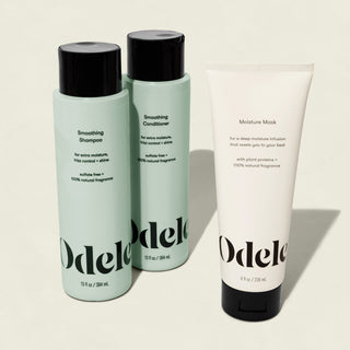 Odele’s Smoothing Set—frizz-fighting Smoothing Shampoo and Conditioner in light green bottles with black caps, plus a white Moisture Mask tube—all stand upright, featuring minimalist black text and design.