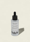 A bottle of Rejuvenating Scalp Serum with a black dropper cap sits on a light beige background. The label notes this serum nourishes the scalp and supports hair density.