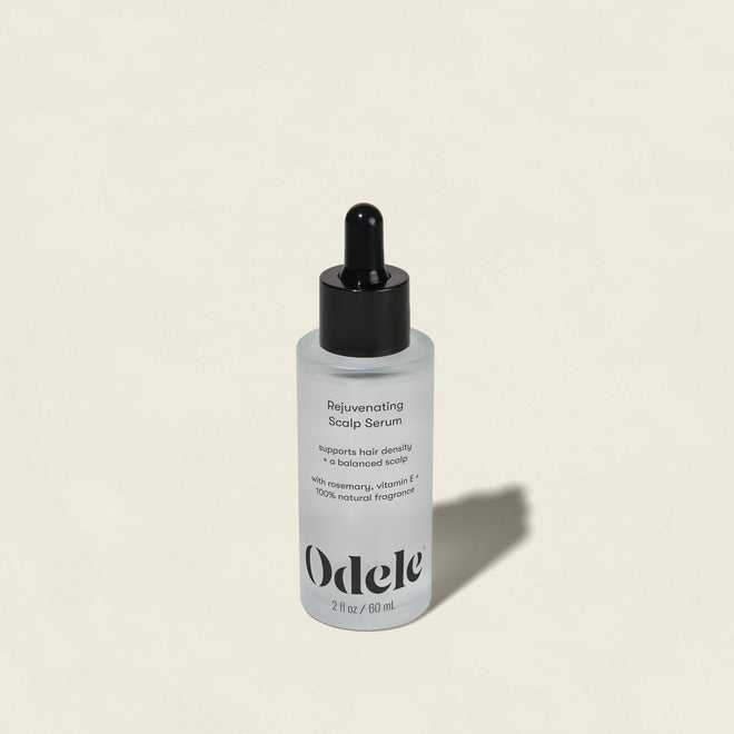 A bottle of Rejuvenating Scalp Serum with a black dropper cap sits on a light beige background. The label notes this serum nourishes the scalp and supports hair density.