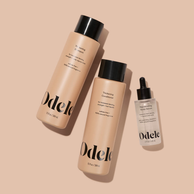 The Odele Beauty Thickening Set is displayed laying down on a plain light orange background.