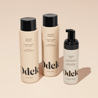 The Odele Volumizing Set stands upright against a plain, light orange backdrop with the front of the labels facing the camera.