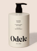 A bottle of Odele Volumizing Shampoo stands upright against a plain light-colored backdrop with the front of the label facing the camera.