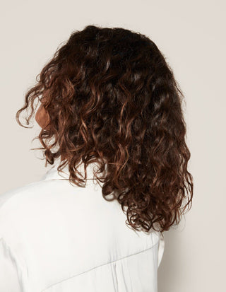 back view person with dark wavy hair
